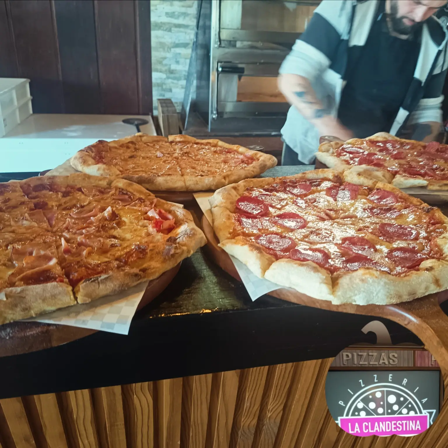 Preparación de pizzas artesanales junto al horno de La Clandestina